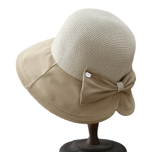 Elegant wide brim sun hat with bow tie and woven straw crown on wooden display