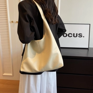 Chic beige lychee leather tote bag with a spacious interior for stylish daily commuting