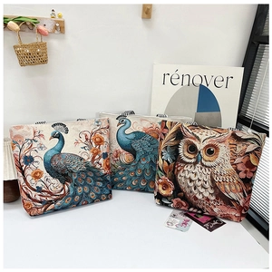 Detail of three vintage canvas tote bags featuring 3D peacock and owl embroidery patterns