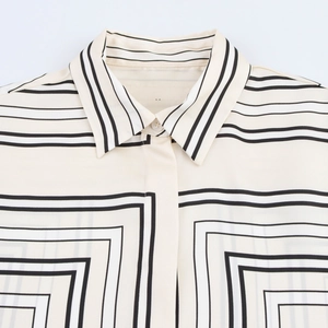 Detail of satin shirt collar with black geometric stripes on beige fabric