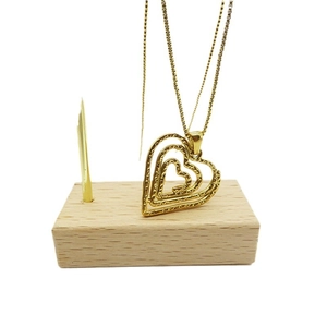 Three-layer 18K gold plated heart pendant necklace with textured finish on wood stand