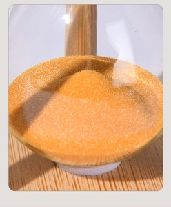 Macro shot of fine orange sand flowing through clear glass in a wooden hourglass frame