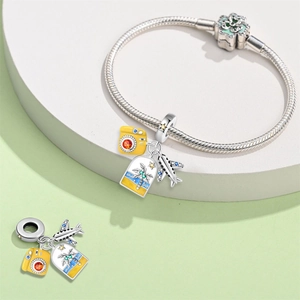 Detailed view of silver charm bracelet with yellow camera and palm tree travel pendants
