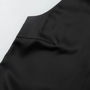 Macro shot of stitching detail on a sleeveless black puff dress with premium matte fabric