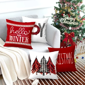 4er-Set Weihnachts-Kissenbezüge mit Wintermotiven und Bäumen auf einem gemütlichen Sofa