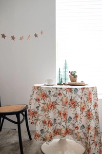 Makroaufnahme der Samttischdecke mit Aquarell-Weihnachtsblumen und festlichen Laternen