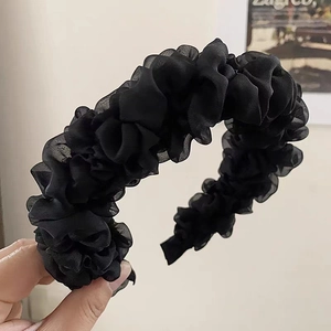 Close-up detail of pleated black tulle fabric on the vintage style padded headband