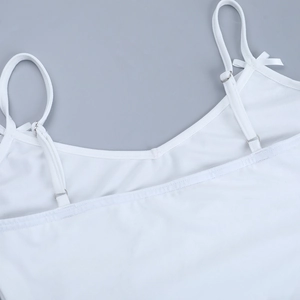 Detail of white camisole with adjustable strap buckle and decorative bow accent