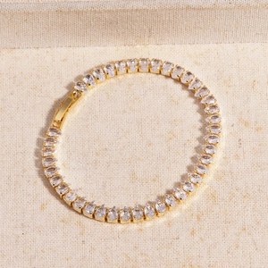 Detail of gold evil eye bracelet with pear-cut cubic zirconia and snap clasp closure