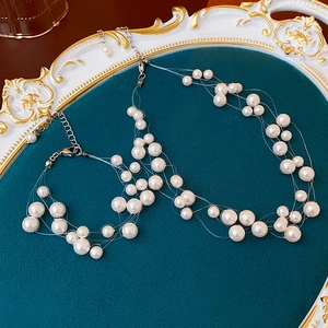 Close-up of multi-layer floating pearl necklace on a vintage velvet display tray
