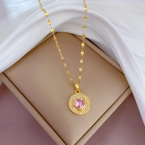 Gros plan du collier en or avec zircon rose en forme de cœur dans son écrin de luxe