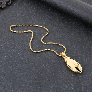 Detailansicht eines goldenen Krabbenschere-Anhängers mit Box-Kette auf schwarzem Hintergrund