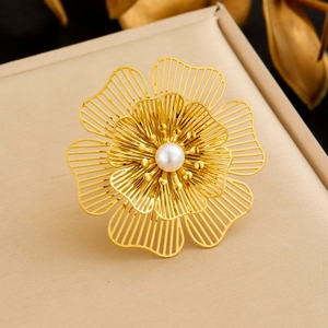 Macro shot of gold plated hollow flower brooch with white pearl in a jewelry box