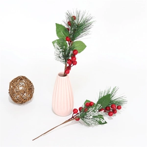 Dettaglio di aghi di pino in PVC con bacche rosse e neve finta per Natale