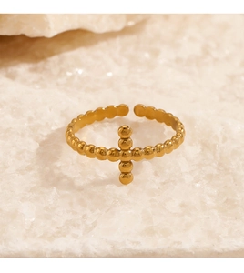 Detailed macro view of 18K gold plated stainless steel cross ring on stone texture