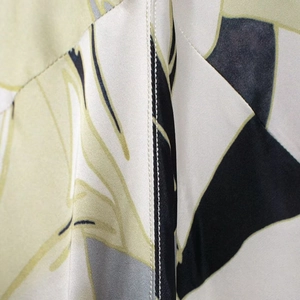 Elegant satin maxi dress with green and beige geometric floral patterns and stitching