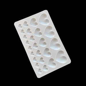 White heart-shaped silicone mold for chocolate and cake decorations on a black background