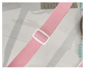 Detailed close-up of pink woven shoulder strap with white adjustable plastic buckle