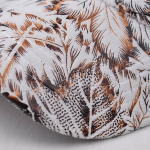 Macro detail of leaf pattern print and precise stitching on white cotton baseball cap