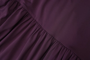 Detailed macro view showing professional ruffle stitching and pleated dark purple fabric