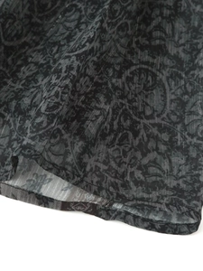 Makroaufnahme von dunkel barock gemustertem Stoff mit Metallgarn und Nahtdetails
