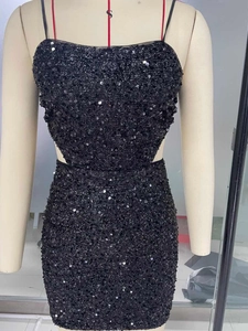 Dettaglio di abito nero con paillettes, spalline sottili e ritaglio in vita su manichino