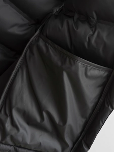 Close-up of the black quilted vest lining with detailed interior pocket and smooth texture