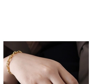 Close-up of 18K gold plated U-link chain bracelet on wrist over a dark background