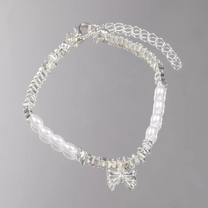 Detailed shot of bow pendant and faux pearls on silver chain with lobster clasp