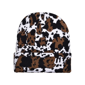 Close-up of knit beanie with cow print pattern showing detailed woven texture and fabric