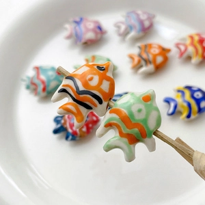 Detailed macro view of colorful handmade ceramic goldfish beads for DIY jewelry making