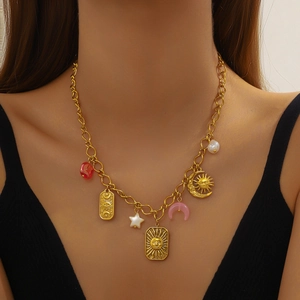 Gold chain necklace with celestial sun moon charms and colorful beads on a female model