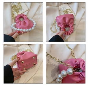Pink faux leather pearl handle handbag with gold chain strap and drawstring closure