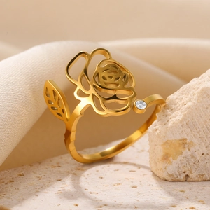 Macro shot of gold rose flower ring with zircon stone on stone and silk background
