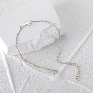 Detailed macro view of S925 sterling silver chain bracelet with horizontal cross pendant