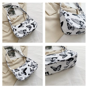 Detailed views of a vintage-style underarm bag with black butterfly prints on white canvas