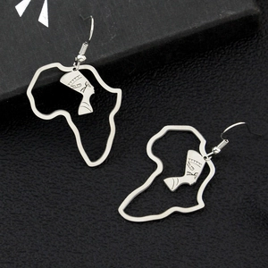 Gros plan détaillé des boucles d'oreilles argentées avec carte d'Afrique et silhouette
