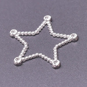 Macro detail of silver pentagram bead charm with smooth metallic beads and texture