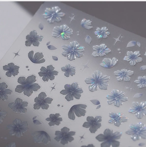 Macro shot of 3D blue cherry blossom nail stickers with laser holographic glitter effect