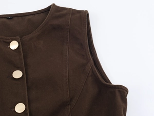 Dettaglio del gilet in velluto a coste marrone scuro con tre bottoni in metallo dorato