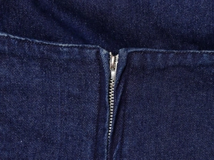 Vue détaillée de la fermeture éclair en métal argenté sur tissu denim bleu foncé