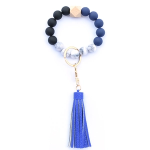 Detail of blue and black silicone beaded wristlet with leather tassel and gold clasp