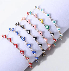Détail de bracelets cœur mauvais œil plaqués or 18 carats sur présentoir blanc