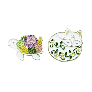 Cute enamel animal pins featuring a white turtle with succulents and a sleeping fox floral badge