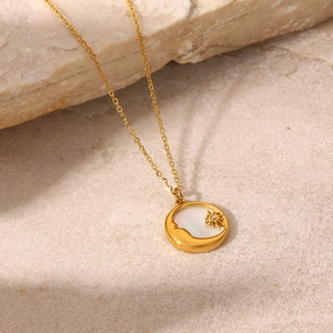 Detailed macro of 18K gold plated celestial pendant with white mother of pearl inlay