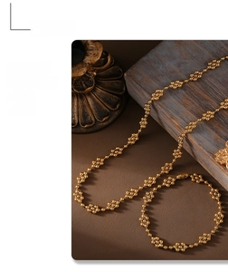 Detail of 18k gold plated beaded cluster link necklace on vintage jewelry display