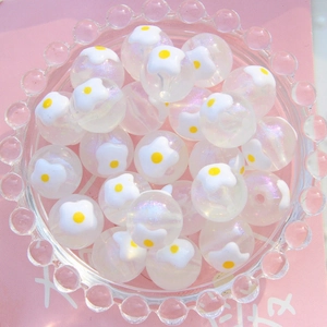 Gros plan de perles acryliques lumineuses de 16mm avec motifs floraux blancs et jaunes