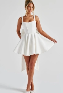 Detail shot of the large decorative bow on the back of this white cocktail mini dress