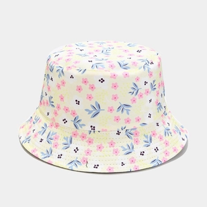 Detail of floral bucket hat with light yellow fabric and colorful flower patterns