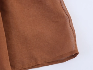 Detailed close-up of brown chiffon fabric texture and high-quality hem stitching